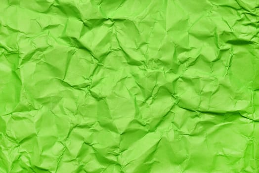 A textured green crumpled paper background with natural creases and folds. Ideal for design projects, digital graphics, or creative presentations requiring a vibrant, tactile surface element