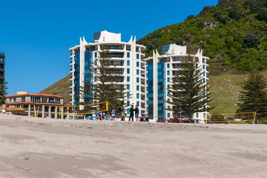 Mount Maunganui New Zealand - November 10 2012; Twin Tower apartments buildings behind beach and volleyball nets.