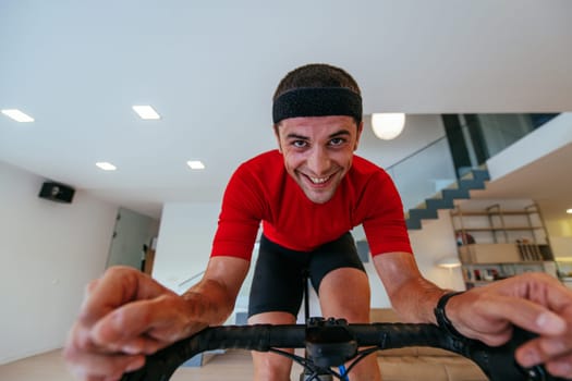A triathlete riding a triathlon bike on a machine simulation in a modern living room. Training during pandemic conditions