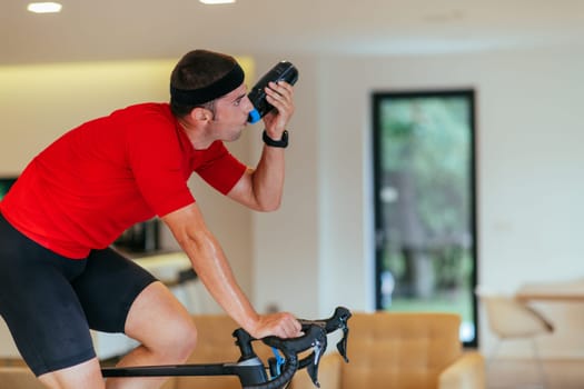 A triathlete riding a triathlon bike on a machine simulation in a modern living room. Training during pandemic conditions