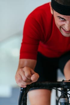 A triathlete riding a triathlon bike on a machine simulation in a modern living room. Training during pandemic conditions