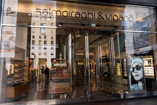 Milan, Italy - April, 08, 2025: Salmoiraghi and Vigano eyewear store exterior. Sunglass displays, Giorgio Armani poster, glass facade. Milan street view.