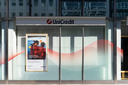 Milan, Italy - April, 08, 2025: UniCredit bank storefront with promotional poster and modern glass facade in daylight. Italian financial institution exterior.