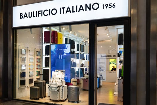 Milan, Italy - April, 08, 2025: Baulificio Italiano 1956 luggage store display with suitcases and bags, illuminated signage and interior shelves.