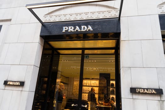 Milan, Italy - April, 08, 2025: Exterior of Prada boutique in Milan with glass doors and luxury interior visible. Elegant designer fashion storefront scene.