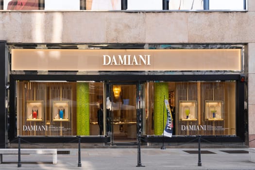 Milan, Italy - April, 08, 2025: Damiani store front view. Luxury jewelry displays with colorful vases and elegant branding. Italian boutique exterior.