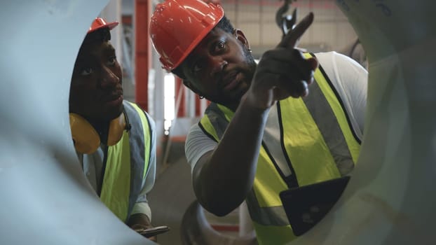 Engineer two worker man African black marking inspection on roll metal sheet before shipment in warehouse of Metal Sheet factory, Physical inventory count, checking stock industry