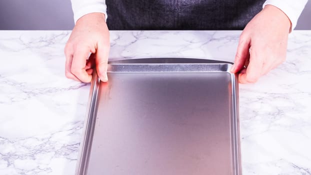 Juicy red strawberries, freshly washed, are spread out to dry on a baking sheet, carefully lined with paper towels to absorb excess moisture and prevent mold.