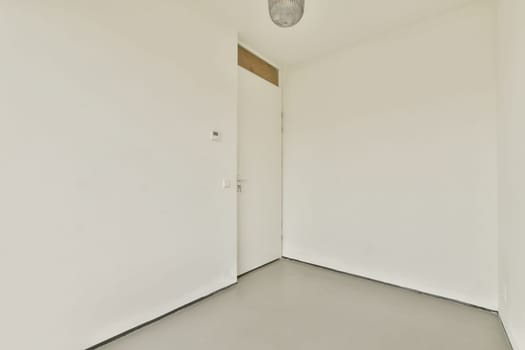 A simple, minimalist room showcasing plain white walls, a door, and a ceiling light, creating an open and airy feel, perfect for modern designs.