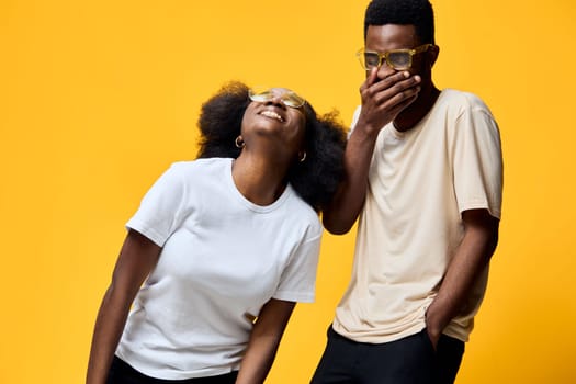 A lively image of two young adults expressing happiness and camaraderie, set against a bright yellow backdrop This image emphasizes friendship, joy, and vibrant emotions, ideal for lifestyle concept