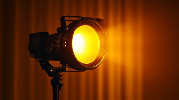 Studio spotlight shining bright with a warm yellow glow in a dark room.