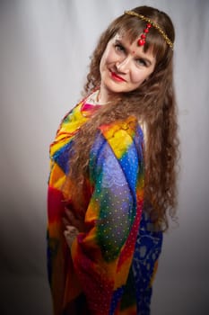 A mature woman in a colorful sari poses confidently, showcasing traditional Indian fashion during a creative photoshoot in a studio setting.