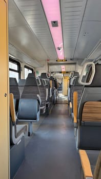 Modern "Deutche Bahn" regional train interior in Germany with empty seats and a spacious layout, illuminated by bright lighting, offers a clean and comfortable atmosphere, perfect for travel enthusiasts and daily commuters