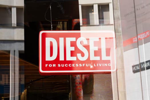 Milan, Italy - April, 08, 2025: Diesel red logo signage. Bold white text For Successful Living on glass storefront in Milan. Closeup urban retail branding.