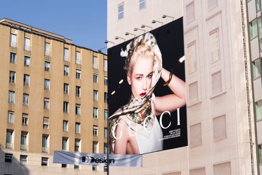Milan, Italy - April, 08, 2025: Large Gucci fashion campaign billboard on city building facade in Milan near metro entrance. Street view.