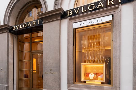 Milan, Italy - April, 08, 2025: Bvlgari boutique storefront with luxury jewelry display. Elegant stone facade, golden interior lights and branded signage in Milan.