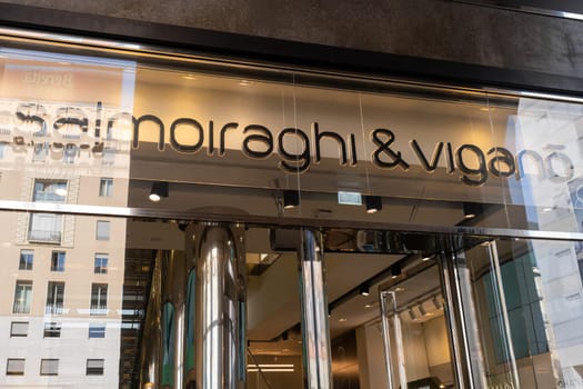 Milan, Italy - April, 08, 2025: Closeup of Salmoiraghi and Vigano eyewear store entrance with chrome columns and brand logo. Milan, Italy. Glass and metal facade.
