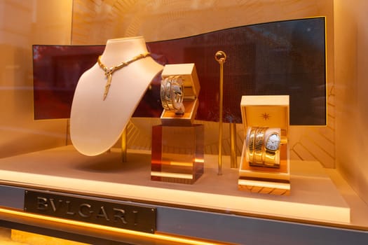 Milan, Italy - April, 08, 2025: BVLGARI jewelry window display. Serpenti necklace, gold bracelets and luxury watch. Milan boutique close-up showcase.