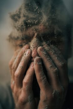 Man with dusty face and hands covering his expression in fear or despair. A powerful visual for illustrating disaster aftermath, emotional trauma, survival, and human fragility