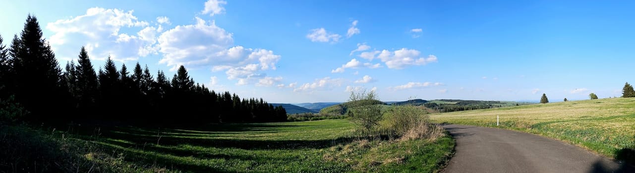 panorama of beautiful countryside of Rhoen, Hesse, Germany. sunny afternoon. wonderful springtime landscape in mountains. grassy field and rolling hills. rural scenery. High quality photo