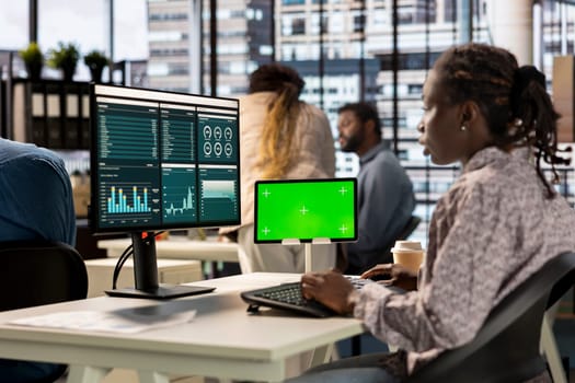 African American businesswoman at office with mockup screen analyzing financial data and developing growth strategies to achieve company success. Analyst managing important tasks.