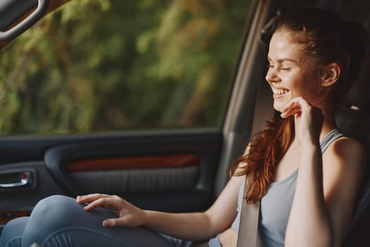A young woman enjoying a moment in her car, wearing casual fitness clothing, exuding happiness and serenity amidst nature Ideal for wellness and lifestyle themes