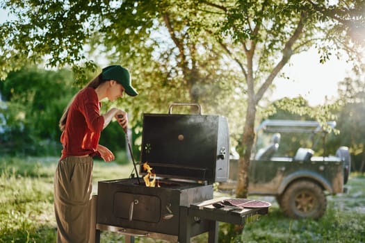 Happy young woman enjoys grilling outdoors in a sunny garden, wearing a red shirt and green cap This vibrant image captures summer BBQ, cooking, and outdoor lifestyle