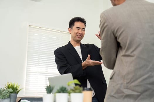 In a contemporary office, two professionals communicate effectively, discussing strategies and ideas for their project, emphasizing teamwork.