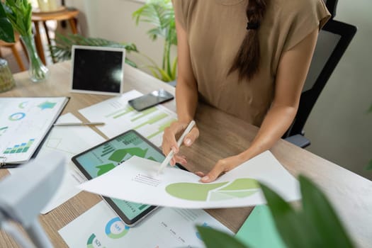A dedicated woman reviewing eco-focused data analysis, reflecting her commitment to sustainable practices and ESG principles.
