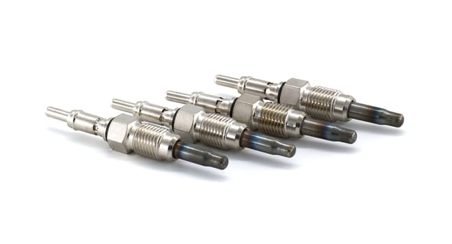 Close-up shot of a set of glow plugs isolated against a white background, showing their intricate details. Perfect for automotive themes.