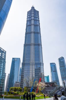 Shanghai, China - 1 April 2025: The majestic Jinmao Tower, an iconic part of Shanghai’s skyline trio, reflects sunlight with its sleek stepped design under clear blue skies