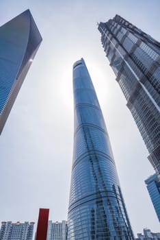 Shanghai, China - 1 April 2025: A dramatic low-angle shot captures Shanghai's iconic trio of skyscrapers: the spiraling Shanghai Tower, the trapezoidal Shanghai World Financial Center, and the tiered Jin Mao Tower
