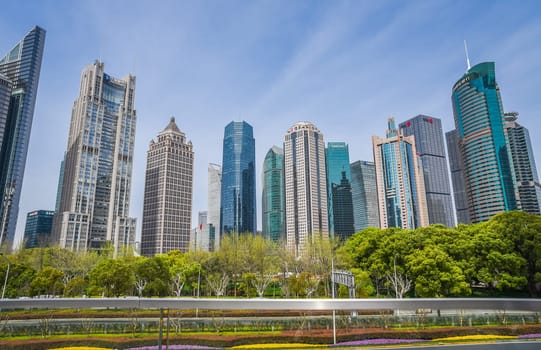 Shanghai, China - 1 April 2025: Sunset over Pudong futuristic skyline, glass towers glowing gold as business professionals cross the wide pedestrian plaza below