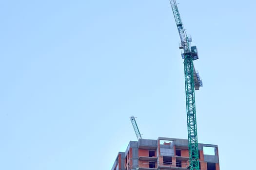 a large, tall machine used for moving heavy objects by suspending them from a projecting arm or beam