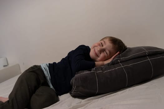 Young boy resting peacefully on a bed, enjoying a moment of quiet comfort and happiness