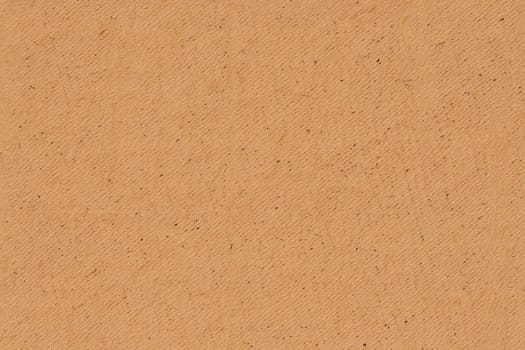A close up view of textured paper reveals a warm orange color with a fine grain and slight variations. The organic feel makes it suitable for creative projects and crafts.