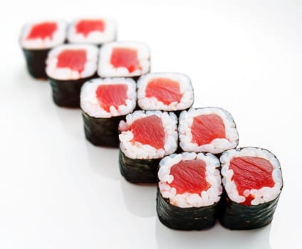 Neatly arranged sushi rolls feature bright red fish and white rice wrapped in seaweed. The presentation highlights the freshness and quality of the ingredients used in sushi preparation.