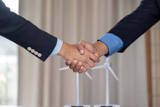 Two professionals shaking hands to symbolize a partnership focused on sustainability and ESG initiatives in a corporate environment.