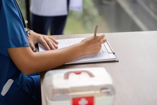 A nurse diligently writing notes on patient information, ensuring accurate documentation in a healthcare setting.