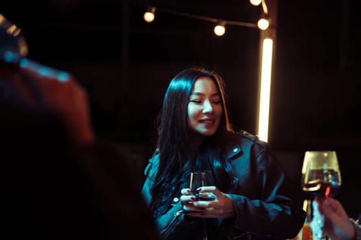 A group of friends enjoys a lively evening gathering, sharing drinks and smiles in a warm, inviting atmosphere illuminated by soft lighting. Laughter fills the air.