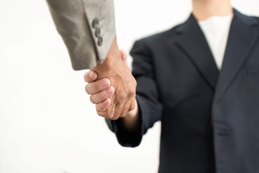 A close-up shot of two business professionals engaging in a handshake, representing commitment and agreement in a corporate setting.