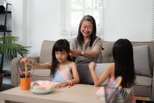 A loving grandmother engages her granddaughters in fun educational activities, fostering a joyful learning environment as they prepare for school.
