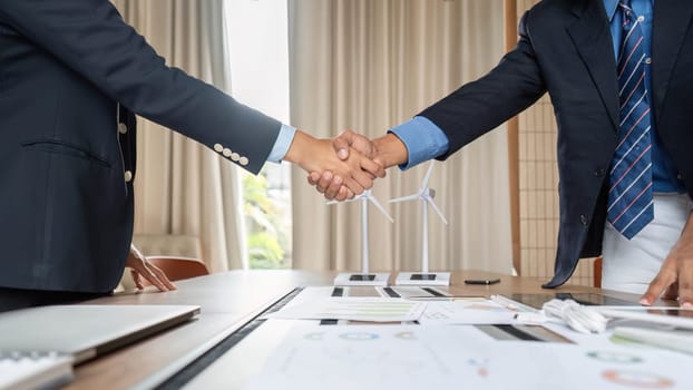 Two businessmen sealing a deal with a firm handshake, emphasizing their partnership in sustainability and ESG initiatives.