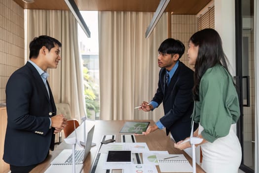 A diverse team of professionals engaged in a sustainability meeting, discussing ESG solutions with enthusiasm and collaboration in a modern office.