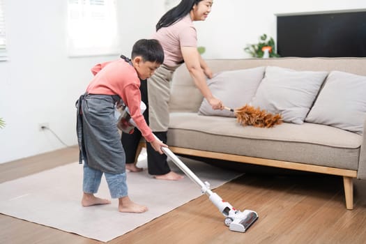 A mother and her son are actively engaged in cleaning their home, showcasing the joy of shared chores and family dynamics in a nurturing environment.