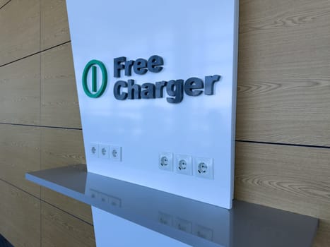 Free charging area with multiple power outlets and USB ports on clean white wall, offering modern solution for charging electronic devices in public indoor space