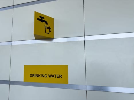 Helpful drinking water direction sign in a public building, designed for traveler convenience with minimalist style and high visibility for quick hydration access