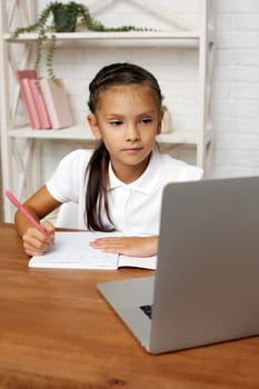 happy little child girl using laptop for studying online e-learning system.
