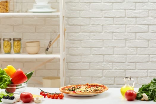 pizza and ingredients are placed on table. Copyspace for text. Cooking concept