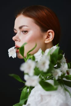 A beautiful woman, showcasing a calm demeanor, poses with white flowers against a dark backdrop This image emphasizes beauty, nature, and tranquility, ideal for health related projects